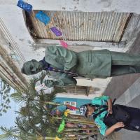 Una scout posando junto a una estatua de Agustín Lara sosteniendo un folleto de promoción del proyecto y portando nuestra pañoleta de grupo