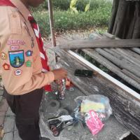 A scout inserting shredded plastic into a bottle at a park