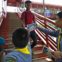 Picture of a scout handing out posters