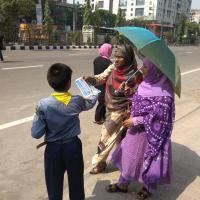 Picture of a scout handing out posters