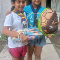 La scout coordinaria del proyecto recibiendo donaciones de otra scout de un grupo hermano