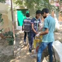 Helping each other by holding the garbage bag. 