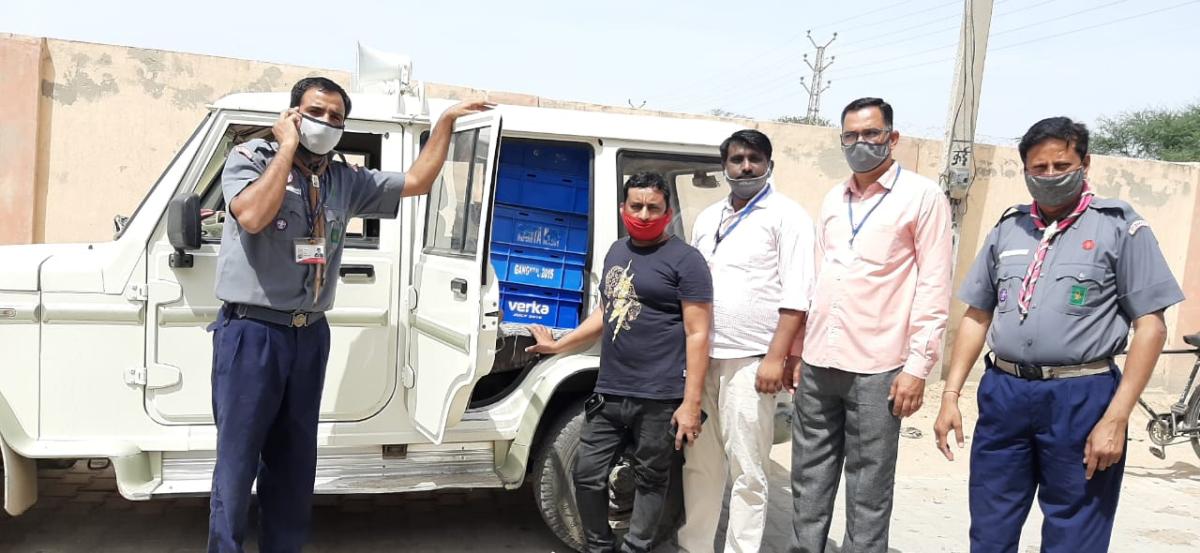 दूध वितरण करते हुए स्काउट यूनिट लीडर