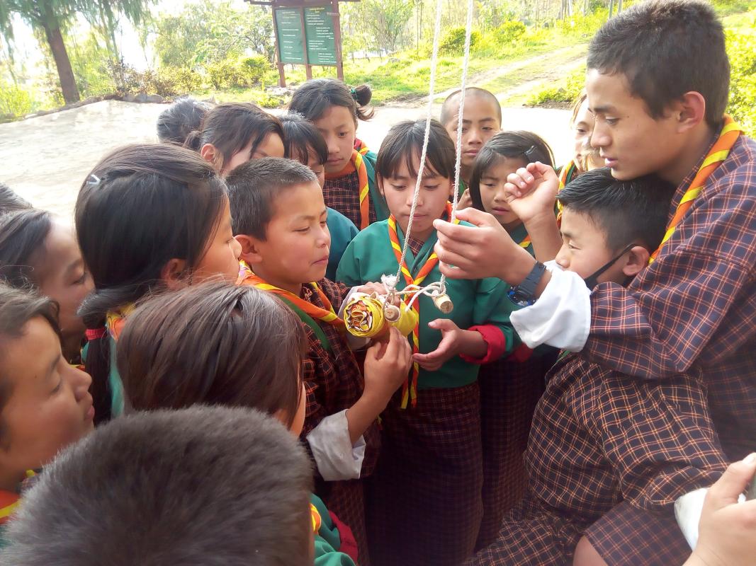 Senior Sixer teaching how to fold the Bhutan National Flag