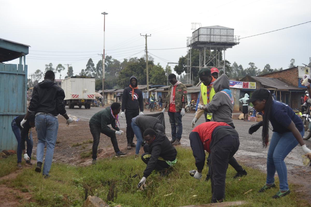 Scouts participate in a market clean up together with community members 