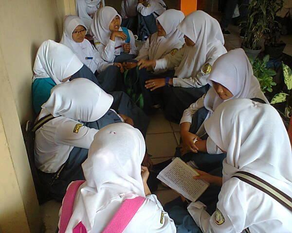 membacakan buku kepada orang lain