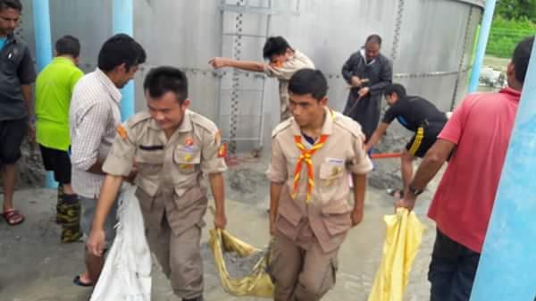 Helping the community to fight against the debris in the water tank of which was affected by flood .