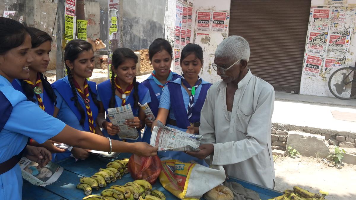 Distibute paper beg different shops and give a message avoid plastic bag 