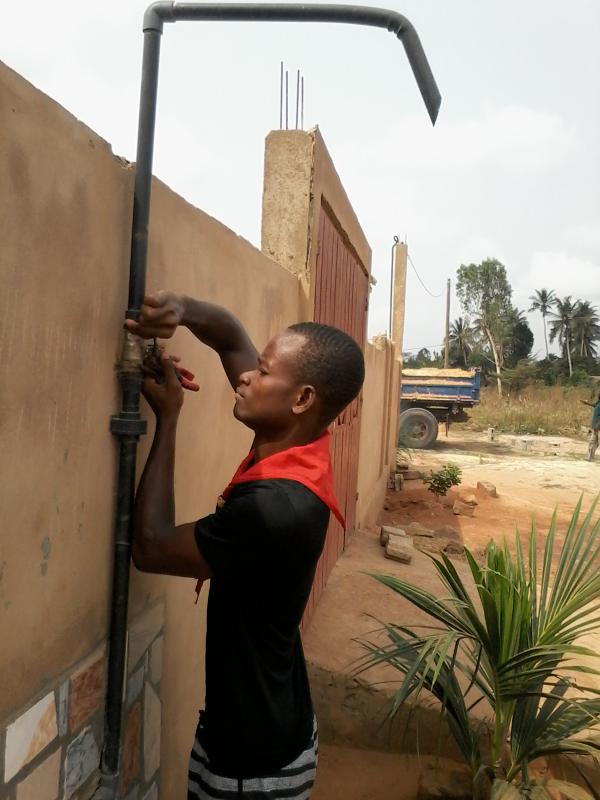 Repairing the faucet of a drinking water pump in Ségbé Zanvi