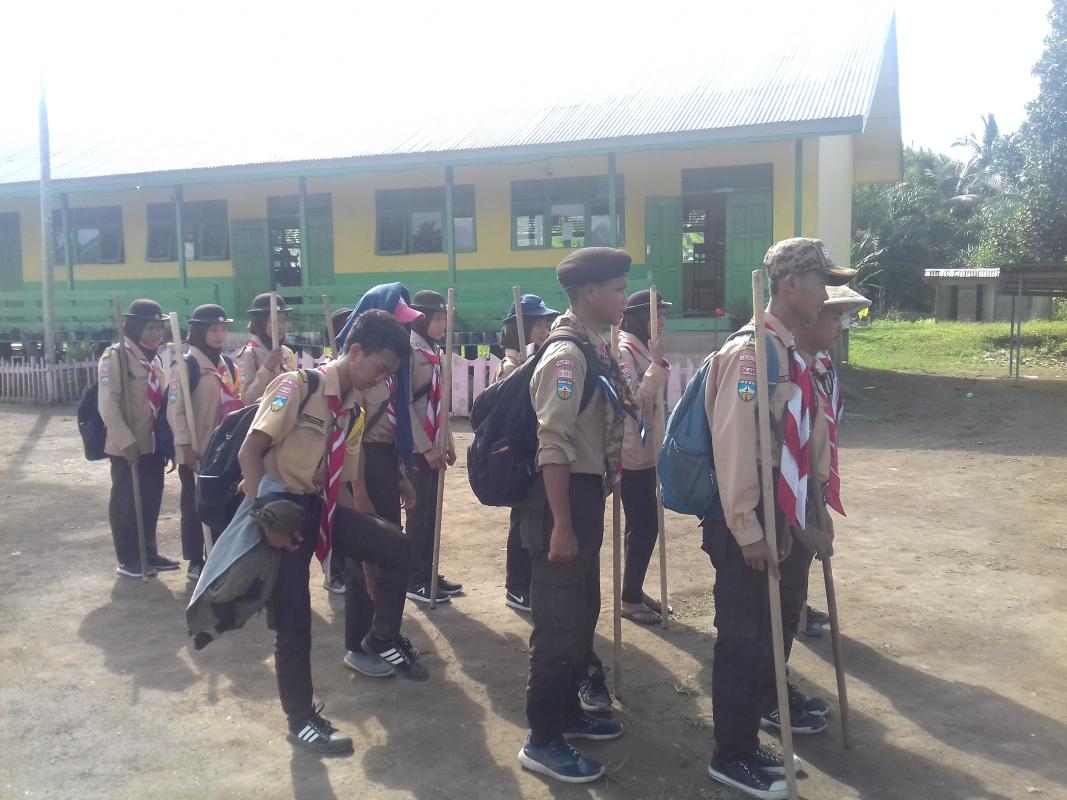 Melaksanakan gotong royong bersama pramuka