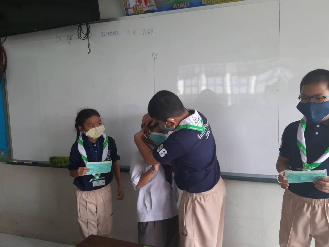 จิตอาสานักเรียนช่วยให้ใส่หน้ากากให้ถูกต้อง
