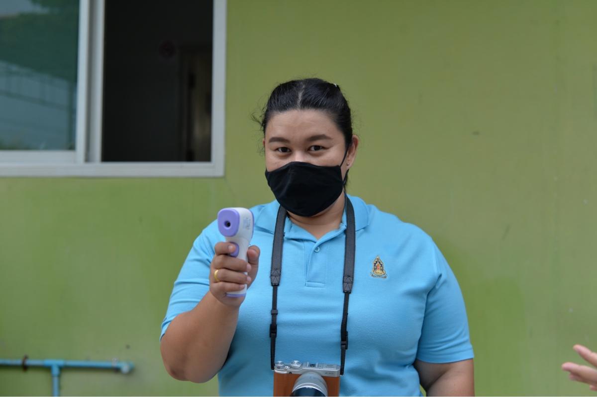 ปฏิบัติหน้าที่ตรวจวัดไข้นักเรียน