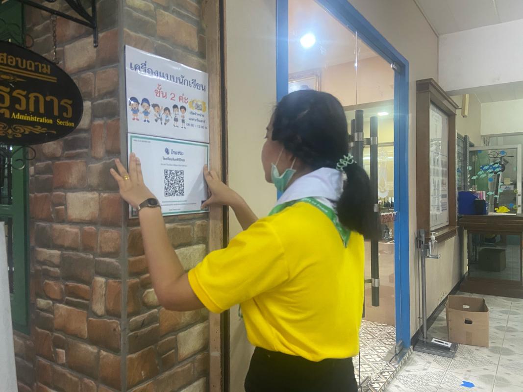จิตอาสา ติดป้ายไทยชนะให้กับผู้มาติดต่อห้องธุรการ