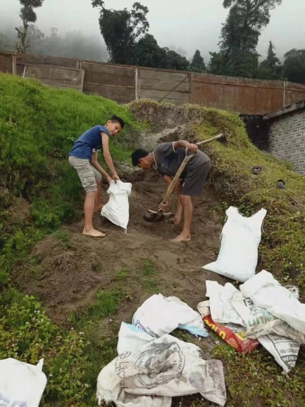 Carrying sand bags for school hand washing basin construction 