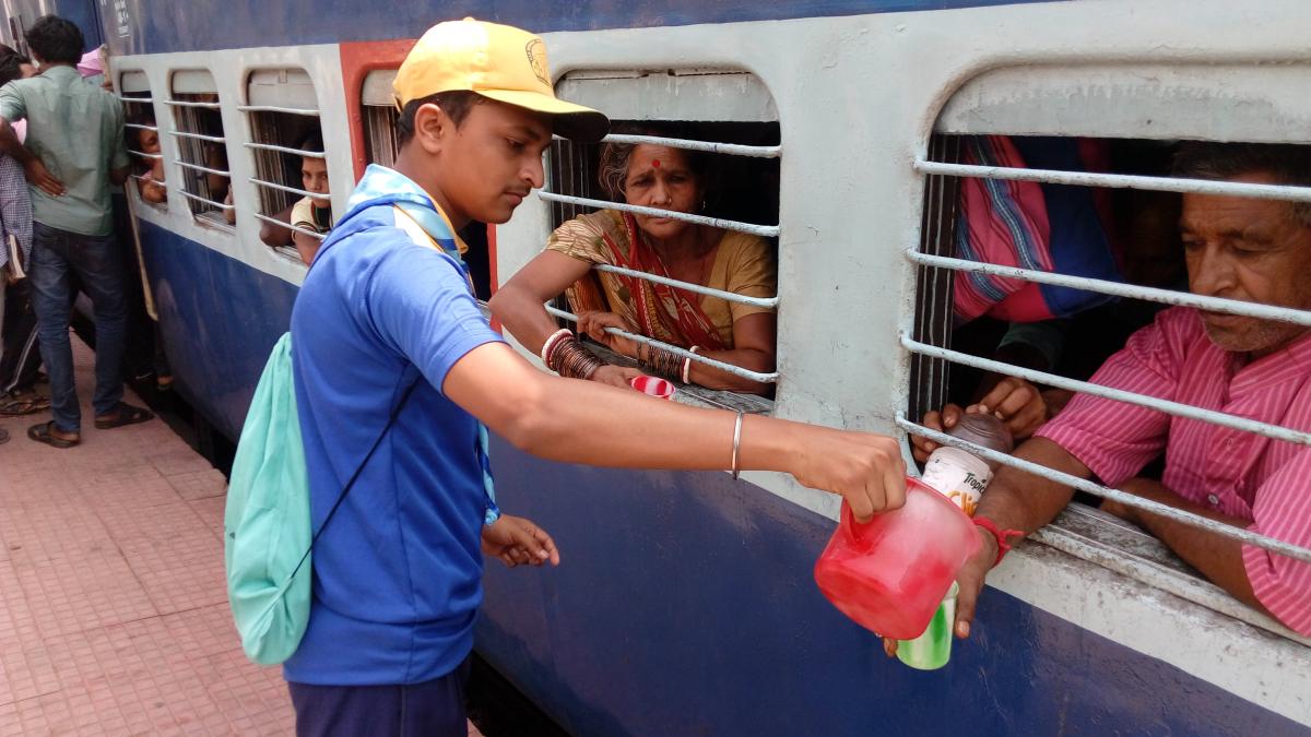 Giving cold water to the thirsty passengers of the train in the hot summer days