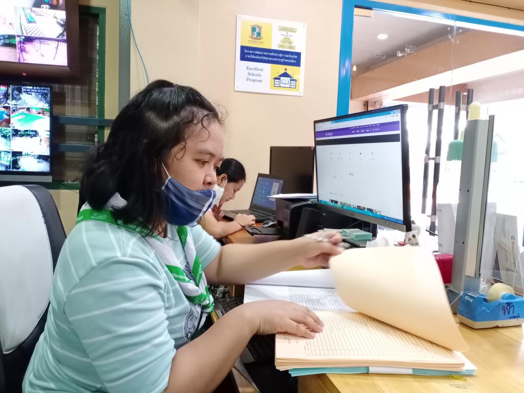 จิตอาสาเช็ครายชื่อนักเรียนที่มาซื้อหนังสือเรียนในช่วงปิดภาคเรียน