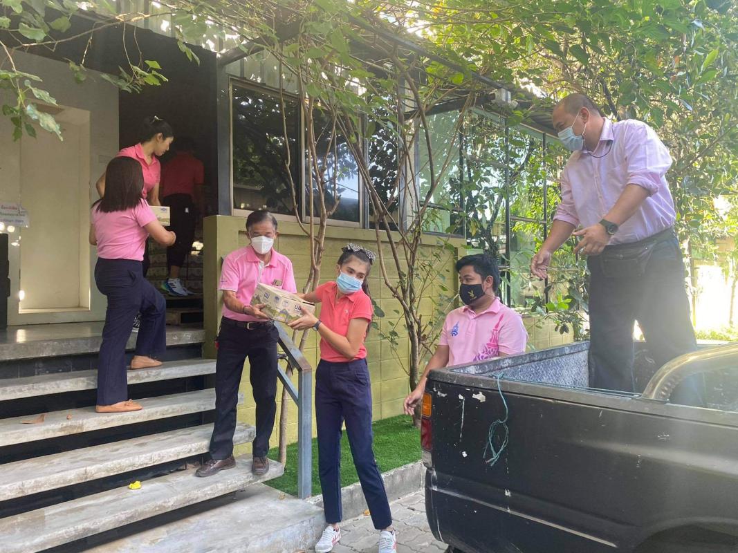 จิตอาสาช่วยยกลังนมเพื่อมอบให้กับนักเรียน