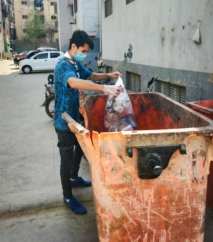 Puting garbage in dustbin. Used disposable gloves and masks for our own protection. 