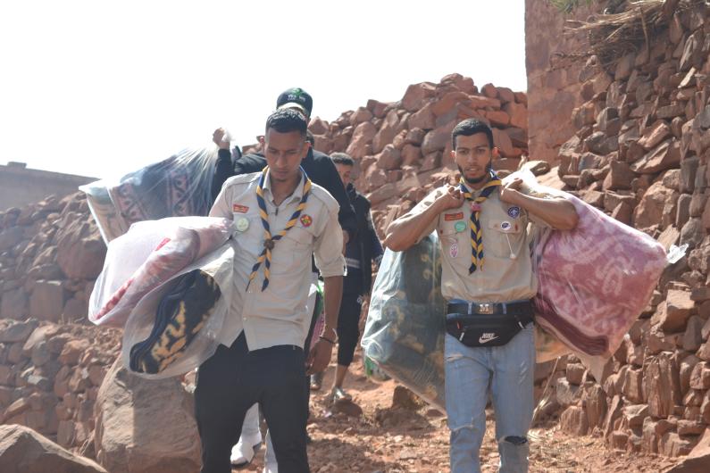Two scouts distribute aid after an earthquake