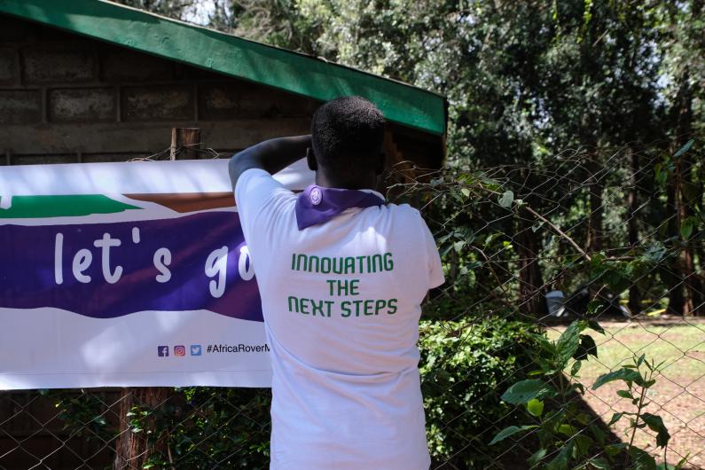 A young scout putting up a banner 