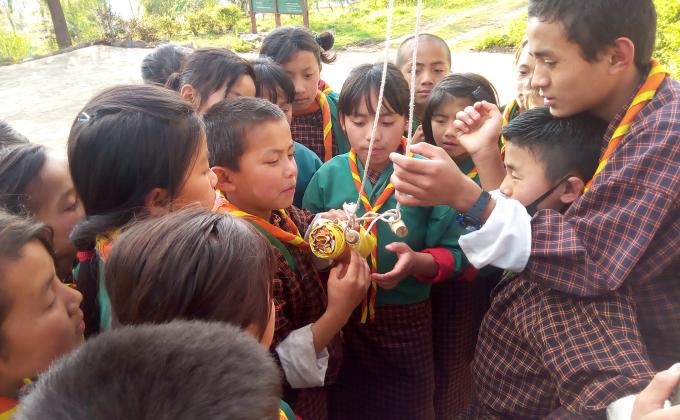 Senior Sixer teaching how to fold the Bhutan National Flag