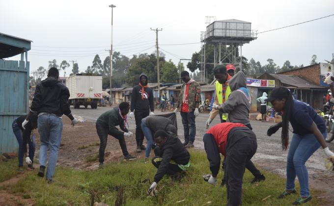 Scouts participate in a market clean up together with community members 