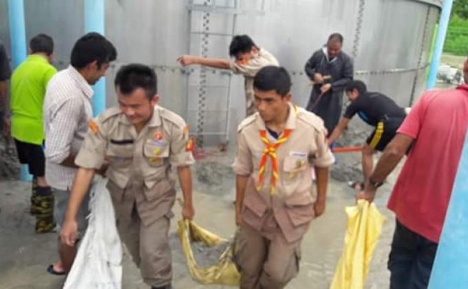 Helping the community to fight against the debris in the water tank of which was affected by flood .