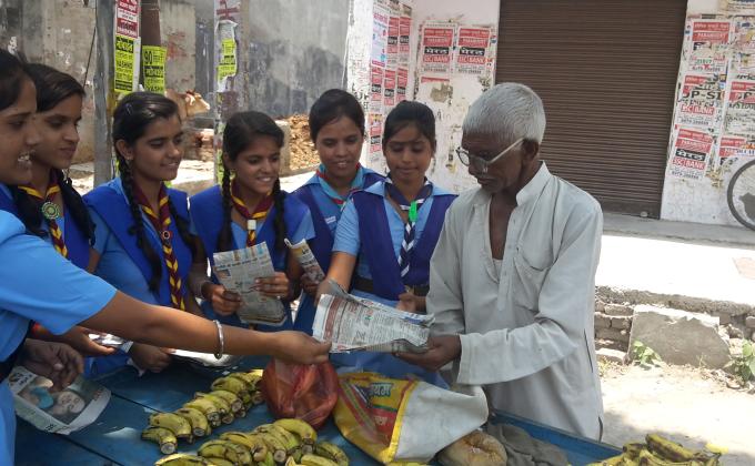 Distibute paper beg different shops and give a message avoid plastic bag 