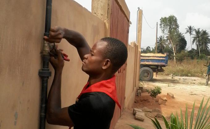 Repairing the faucet of a drinking water pump in Ségbé Zanvi
