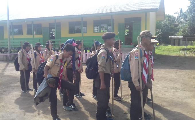 Melaksanakan gotong royong bersama pramuka