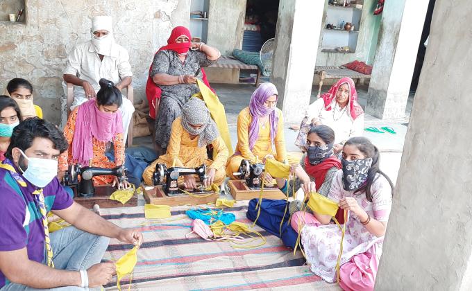 कोरोना महामारी से निपटने के लिये मास्क बनाते हुए । 