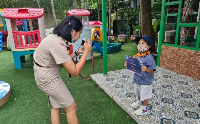 จิตอาสาถ่ายภาพถือป้ายคำมั่นสัญญาให้กับนักเรียน