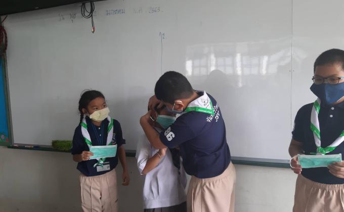 จิตอาสานักเรียนช่วยให้ใส่หน้ากากให้ถูกต้อง