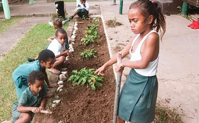 Years 1&2 of Lololo Primary School Planting flowers to Beautify the School.
