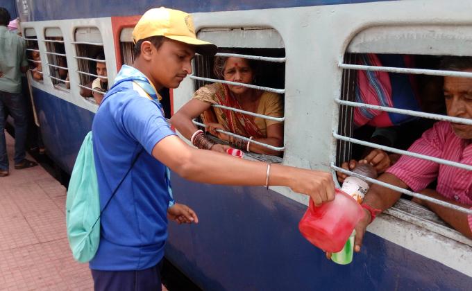 Giving cold water to the thirsty passengers of the train in the hot summer days