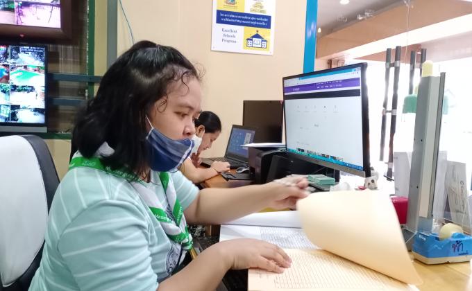 จิตอาสาเช็ครายชื่อนักเรียนที่มาซื้อหนังสือเรียนในช่วงปิดภาคเรียน