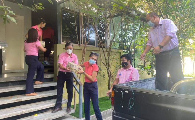 จิตอาสาช่วยยกลังนมเพื่อมอบให้กับนักเรียน