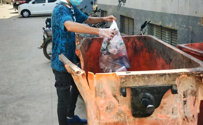 Puting garbage in dustbin. Used disposable gloves and masks for our own protection. 